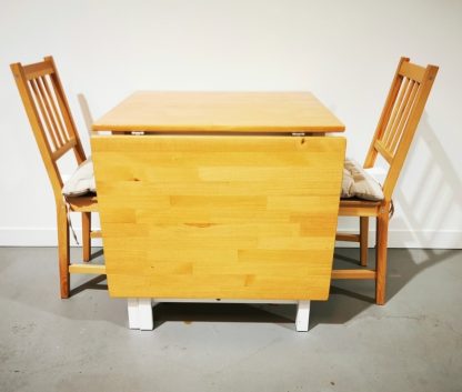 Ikea PINNTORP drop Leaf table with two chairs and cushion pads.